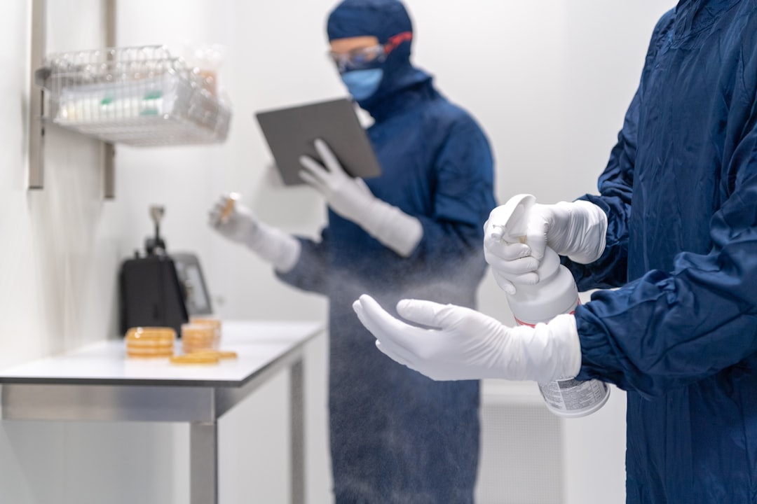 Laboratory technician disinfecting hands with disinfection spray.